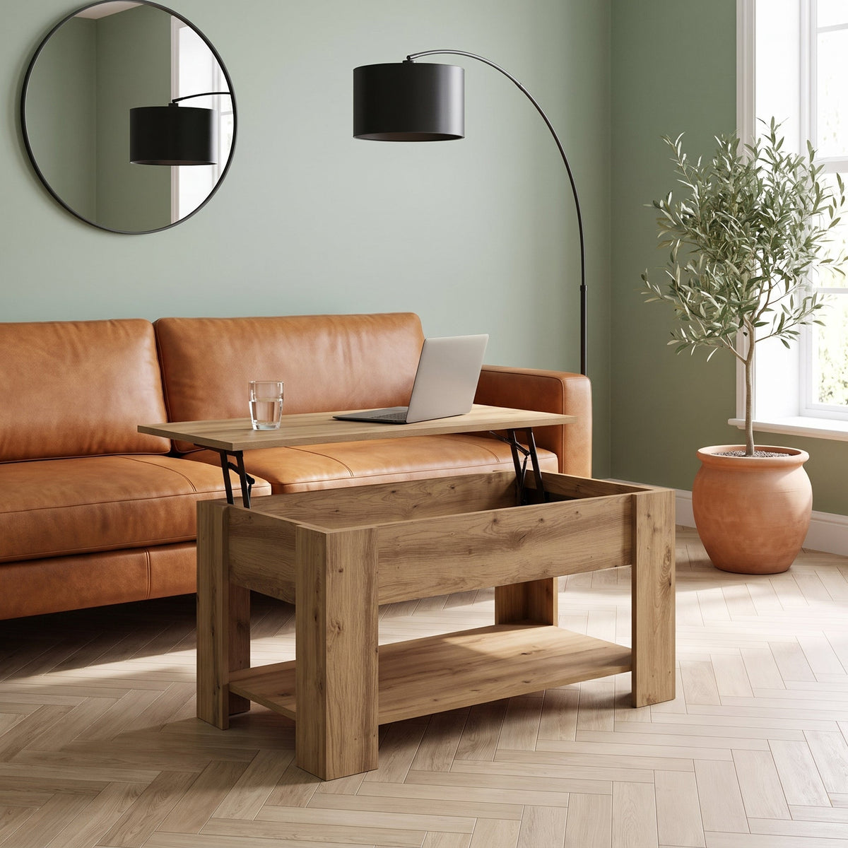 Table Aveline plateau relevé avec ordinateur portable devant un canapé en cuir cognac #Dimensions_101 × 49 × 52 cm #Couleur_Chêne artisanal