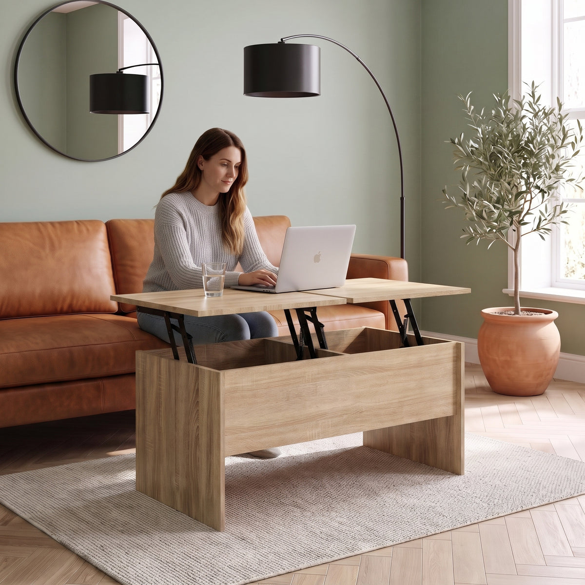 Table basse relevable décor chêne avec coffre Maela chêne sonoma , 102 × 50,5 × 46,5 cm au quotidien : télétravail depuis le canapé, ordinateur sur le plateau relevé #Couleur_Chêne Sonoma #Dimensions_102 × 50,5 × 46,5 cm