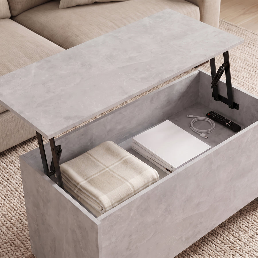 Table basse relevable Velia gris béton, coffre ouvert sous le plateau relevé